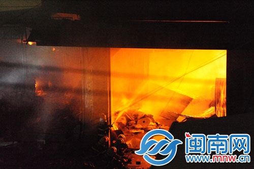 倉庫火勢很旺,消防員用水槍壓制