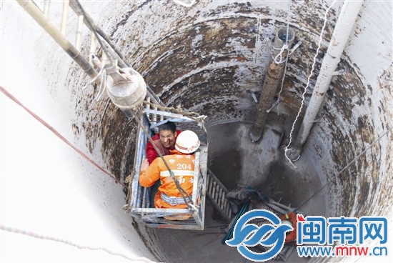 吊機將受傷工人和消防隊員吊出污水處理罐