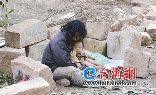 女子帶小孩睡地上