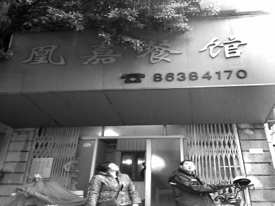 洪鳳媚站在自家店門口，看著“凰嘉餐館”4個字黯然