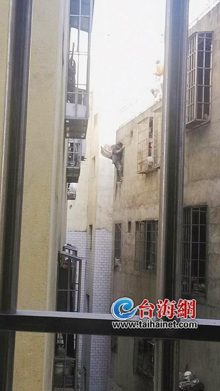 男子攀爬在5樓窗戶的護欄上