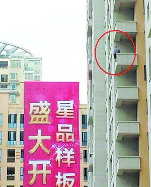 該男子爬上高樓，半身懸空，十分危險