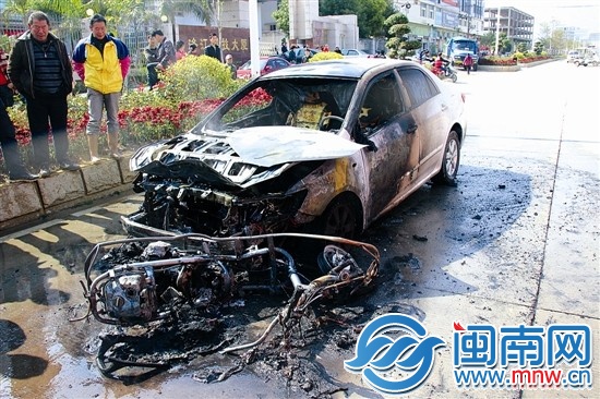 火被撲滅后，小車前躺著一輛被燒得只剩鋼架的助力車