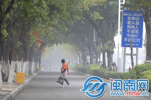 一名環(huán)衛(wèi)工在霧中清掃