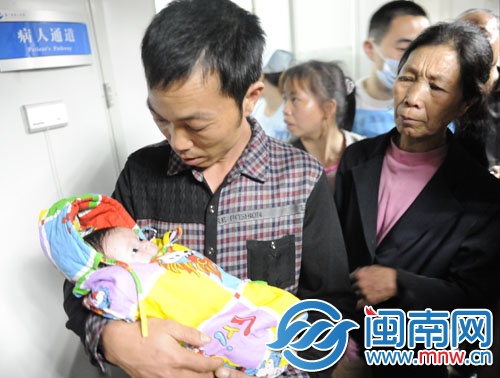 寶寶在叔叔的懷中，睜著大眼好奇地張望著