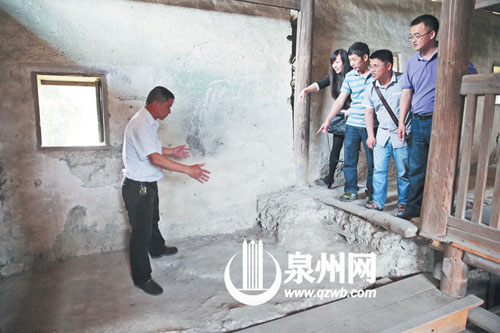 許進丁向游客們比劃著土樓墻體的厚度，當年建造土樓